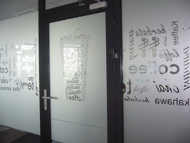 Wylepianie szyb w biurowcu grafiką wyciętą z folii polimerowej samoprzylepnej imitującej piaskowanie szkła, tj. mrożonego szkła w kolorze srebrnym