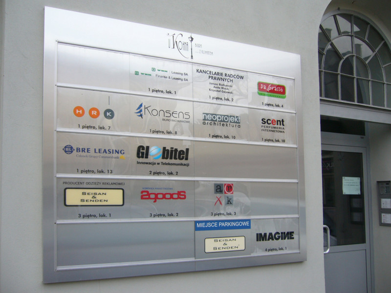 Tablica informacyjna wykonana z dibondu szczotkowanego, z tabliczkami z pleksi bezbarwnej.